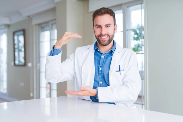 英俊的医生男子穿着医疗外套在诊所手势与双手显示大尺寸的标志 测量符号 微笑着看着相机 测量概念 — 图库照片