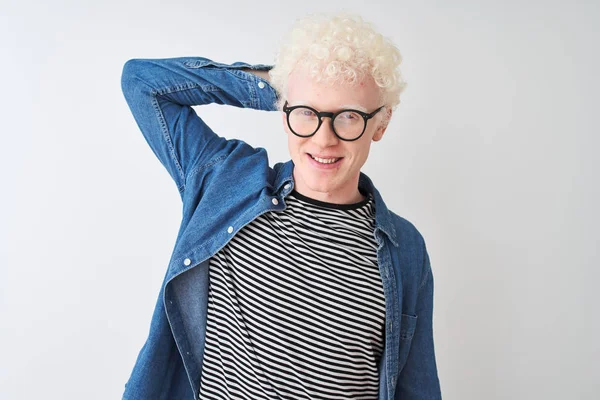 Genç albino sarışın adam denim gömlek ve gözlük izole beyaz arka plan üzerinde el kadar jest ile emin dokunmadan saç gülümseyen giyen, çekici ve şık poz