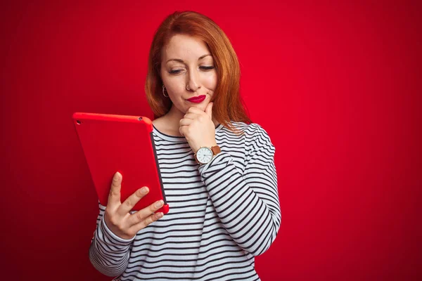 Joven Hermosa Pelirroja Usando Tableta Sobre Fondo Rojo Aislado Cara —  Fotos de Stock