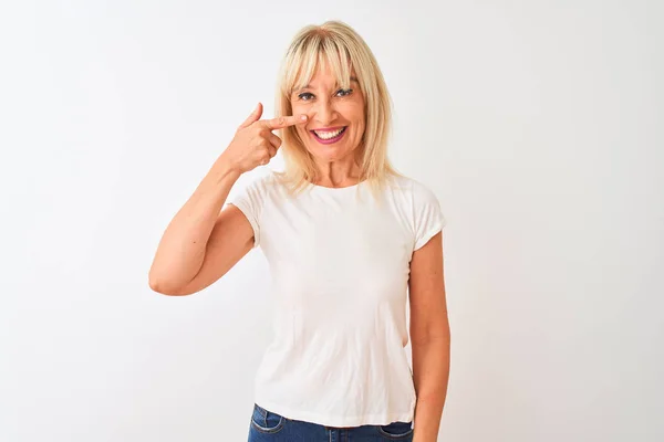 中年妇女穿着休闲T恤站在孤立的白色背景上 用手指着脸和鼻子 面带微笑 美容理念 — 图库照片