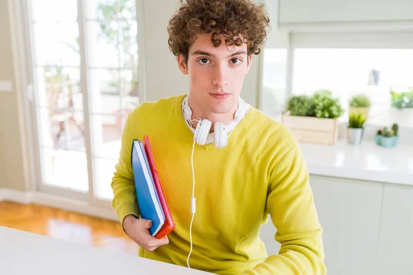 Giovane Studente Uomo Indossando Cuffie Tenendo Quaderni Con Espressione Fiduciosa — Foto Stock