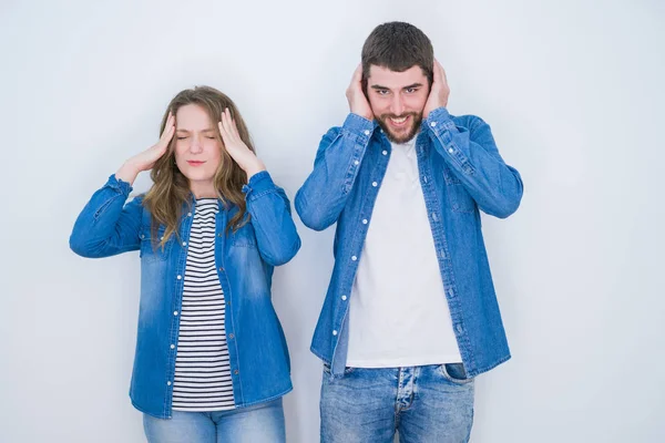 年轻美丽的夫妇站在一起的白色孤立的背景与手在头上疼痛的头部 因为压力 患有偏头痛 — 图库照片