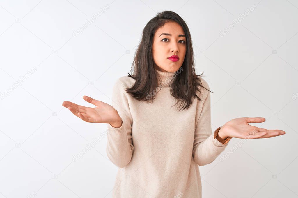 Beautiful chinese woman wearing turtleneck sweater standing over isolated white background clueless and confused with open arms, no idea concept.