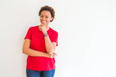 Emin çapraz kollar ve çeneme kaldırdı el ile gülümseme ile kameraya bakarak beyaz arka plan üzerinde genç güzel Afrikalı-Amerikalı kadın. Pozitif düşünce.