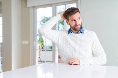 Rahat kazak giyen yakışıklı adam kafasını karıştırıyor ve merak ediyor. Şüpheyle belirsiz, eliyle kafada düşünmek. Pensive kavramı.