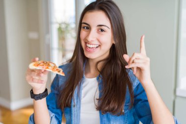 Lezzetli pizza bir dilim yemek güzel genç kadın çok mutlu yan el ve parmak ile işaret