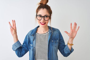Redhead kadın çizgili t-shirt denim gömlek ve gözlük izole beyaz arka plan üzerinde gösteren ve parmakları ile işaret eden sekiz parmaklar ile yüzerken emin ve mutlu gülümseyerek.
