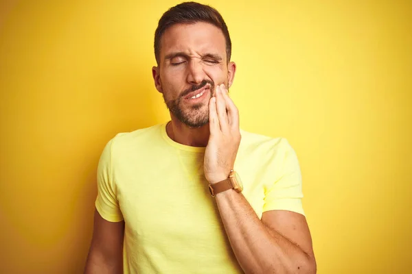 年轻的英俊男子穿着休闲黄色T恤在黄色孤立的背景触摸嘴与手与痛苦的表情 因为牙痛或牙齿疾病 牙医概念 — 图库照片