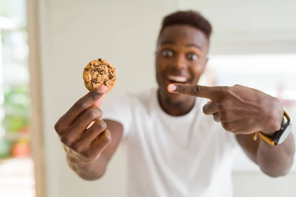 Joven Afroamericano Hombre Comiendo Galletas Chips Chocolate Muy Feliz Señalando — Foto de Stock