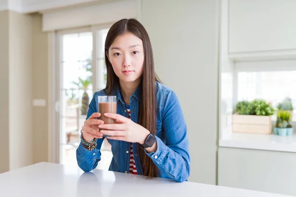 美丽的亚洲女人喝一杯新鲜的巧克力奶昔与自信的表情在聪明的脸思考认真 — 图库照片