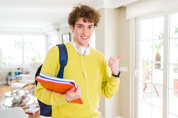 Giovane Studente Uomo Indossando Cuffie Zaino Possesso Quaderni Puntando Mostrando — Foto Stock