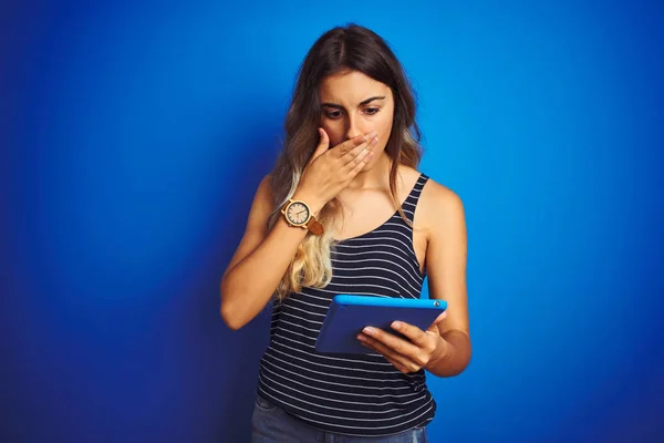 年轻美女使用触摸板平板电脑在蓝色孤立的背景封面嘴与手震惊与耻辱的错误 表达恐惧 害怕在沉默 秘密概念 — 图库照片