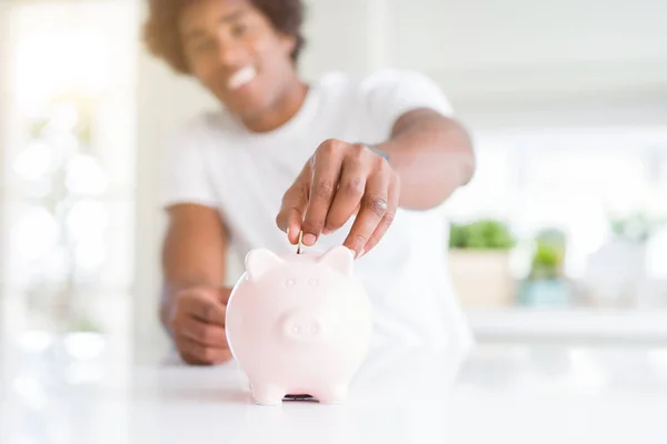 Primer plano del hombre afroamericano ahorrando dinero poniendo una moneda — Foto de Stock