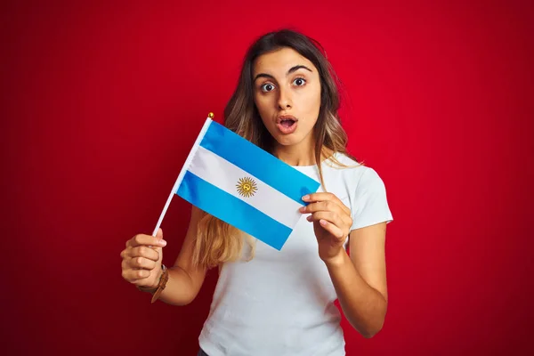 Joven Mujer Hermosa Sosteniendo Bandera Argentina Sobre Fondo Rojo Aislado —  Fotos de Stock