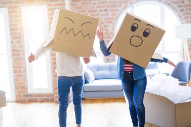 Çılgın çift kafa üzerinde komik yüzler ile kutuları giyiyor, yeni bir eve taşımak için mutlu eğlenceli