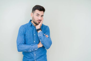 İzole arka plan düşünme seyir üzerinde genç yakışıklı adam yorgun ve sıkılmış çapraz silah depresyon sorunları ile.