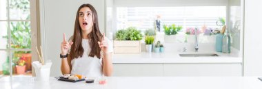 Doğumdan asya suşi yiyen güzel genç kadının geniş açılı resmi şaşırttı ve şaşırttı yukarı bakarak ve parmakları ile işaret ve kolları kaldırdı.