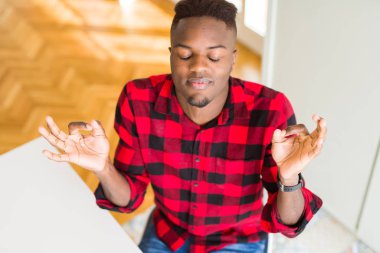 Yakışıklı afro-amerikan adam havai açı dinlenmek ve gözleri parmakları ile meditasyon jest yapıyor kapalı gülümseyerek. Yoga konsepti.