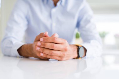 Beyaz masa üzerinde çapraz eller ile adam yakın