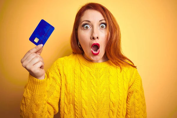 Młody Klient Rudowłosy Kobieta Posiadania Karty Kredytowej Żółtym Białym Tle — Zdjęcie stockowe