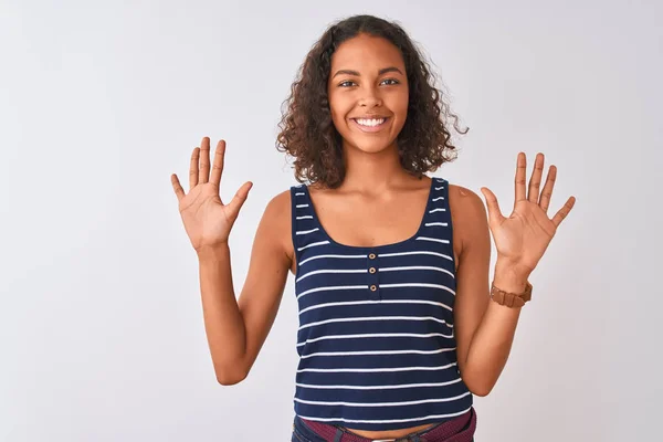 孤立した白い背景の上に立つストライプのTシャツを着た若いブラジル人女性は 自信を持って幸せに微笑みながら 指番号10を示し 指を上げている — ストック写真