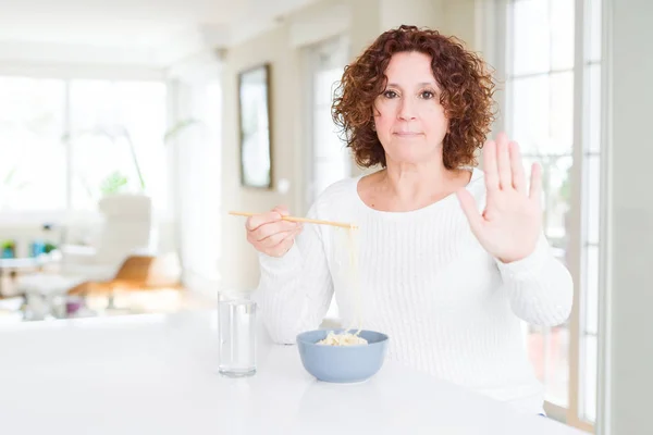 Donna Anziana Mangiare Tagliatelle Asiatiche Utilizzando Bacchette Con Mano Aperta — Foto Stock