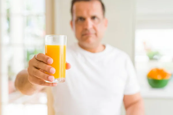 中年男子在家喝了一杯橙汁 聪明的脸上自信的表情思考着严肃 — 图库照片