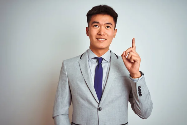 亚洲华商身着西装 打着领带 站在孤立的黄色背景上 指着手指 提出成功的想法 退出和快乐 — 图库照片