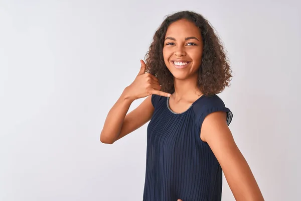 青いドレスを着た若いブラジル人女性は 孤立した白い背景の上に立って 電話で話すような手と指で電話ジェスチャーをして微笑んでいます 概念の伝達 — ストック写真