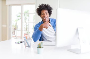 Sürpriz ile bilgisayar kullanarak çalışan Afrikalı-Amerikalı erkeğin karşısında kendine işaret parmağı