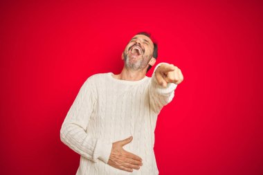 Izole kırmızı arka plan üzerinde gri saçlı yakışıklı orta yaş yaşlı adam size gülüyor, vücut üzerinde el ile kameraya parmak işaret, utanç ifade