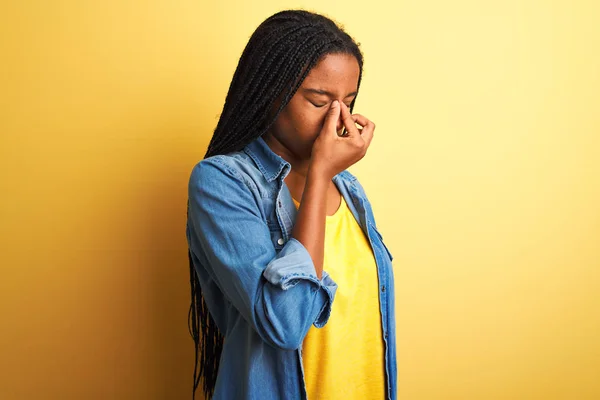 Młoda Afroamerykanka Dżinsowej Koszuli Stojąca Nad Odizolowanym Żółtym Tłem Zmęczona — Zdjęcie stockowe