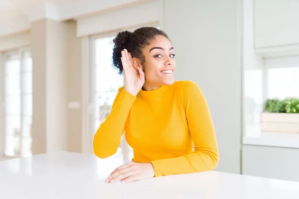美丽的非洲裔美国妇女 头发与休闲黄色毛衣微笑 手在耳朵上听听传闻或八卦 耳聋概念 — 图库照片