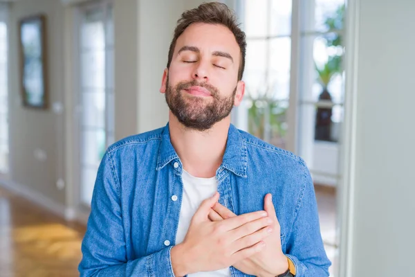 Knappe Man Thuis Glimlachend Met Handen Borst Met Gesloten Ogen — Stockfoto