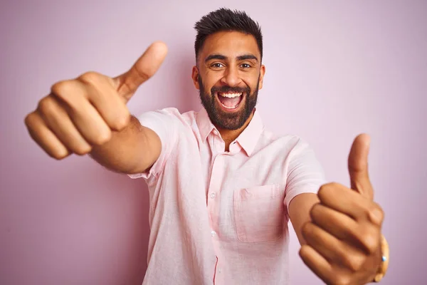 분홍색 서있는 캐주얼 셔츠를 남자는 손으로 긍정적 제스처를하고 손가락으로 미소를 — 스톡 사진