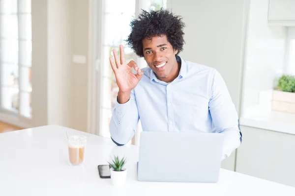 優秀なシンボルの指で サインをしているノート パソコンを使用してアフリカ系アメリカ人ビジネスマン — ストック写真