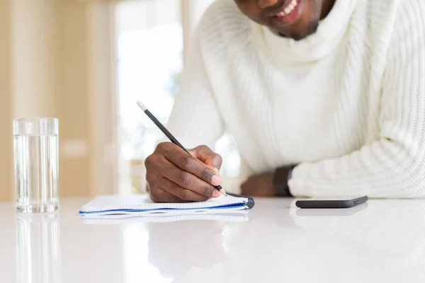 Close Van Afrikaanse Man Schrijven Een Briefje Een Papier Glimlachend — Stockfoto