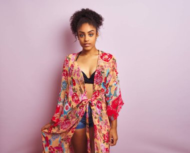 Genç güzel afro-amerikan kadın bikini ve renkli kaftan giyen ayakta tatilde