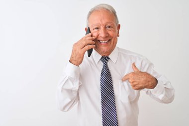 Üst düzey gri saçlı işadamı kendini parmak işaret sürpriz yüz ile izole beyaz arka plan üzerinde akıllı telefon konuşuyor