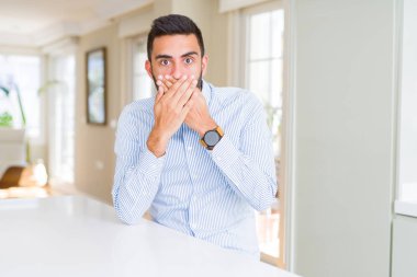 Yakışıklı İspanyol iş adamı hata için elleri ile ağız kapsayan şok. Gizli kavram.