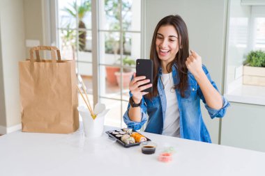 Güzel genç kadın akıllı telefon kullanarak uygulamadan gıda teslimatı sipariş gurur çığlık ve zafer ve başarı kutluyor çok heyecanlı, tezahürat duygu