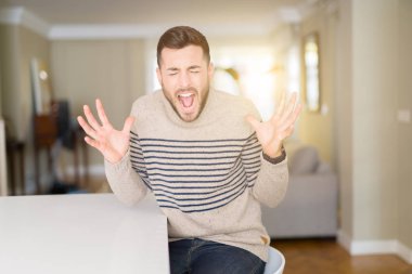 Genç yakışıklı adam evde bir kazak giyen deli ve heyecan çığlık kapalı gözleri ile başarı için deli kutluyor. Kazanan kavramı