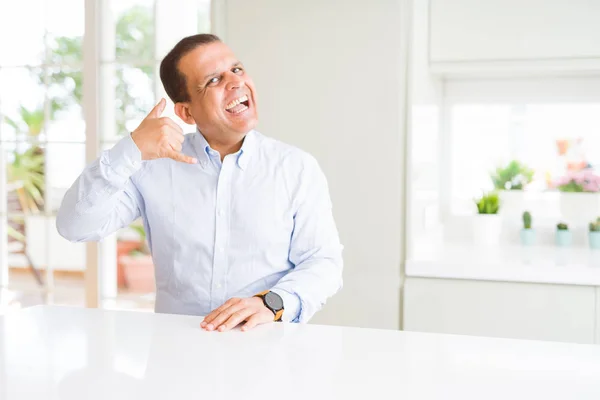 Hombre Mediana Edad Sentado Casa Sonriendo Haciendo Gesto Telefónico Con —  Fotos de Stock