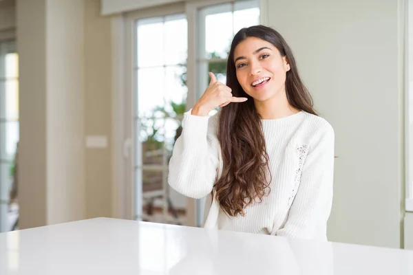 Jovem Mulher Bonita Casa Mesa Branca Sorrindo Fazendo Gesto Telefone — Fotografia de Stock