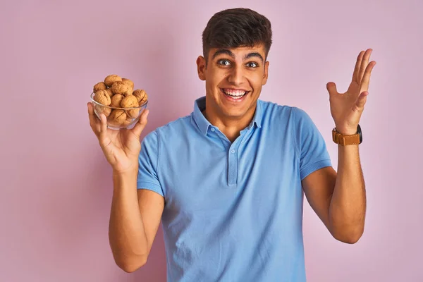 Young Indian Man Holding Bowl Walnuts Standing Isolated Pink Background — Stock Photo, Image