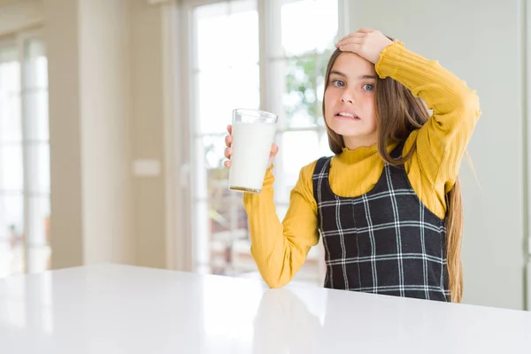 新鮮なミルクのグラスをドライク美しい若い女の子は 頭の上に手でストレスを感じ 恥と驚きの顔でショックを受け 怒りとイライラしました 間違いに対する恐怖と動揺 — ストック写真