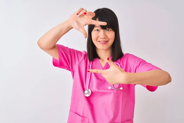 年轻美丽的中国护士妇女穿着听诊器在孤立的白色背景微笑 用手和手指与幸福的脸框 创意与摄影理念 — 图库照片