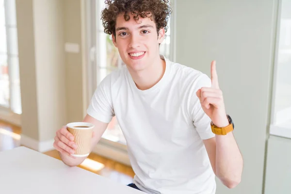 自宅でコーヒーを飲む若い男は 幸せな顔で指を指すアイデアや質問に驚き ナンバーワン — ストック写真