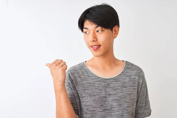 Молодой Китаец Обычной Футболке Стоит Изолированном Белом Фоне Показывая Пальцем — стоковое фото