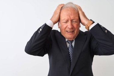 Üst düzey gri saçlı işadamı takım elbise giyen izole beyaz arka plan üzerinde ayakta baş ağrısı umutsuz muzdarip ve stresli çünkü ağrı ve migren. Eller baş üstünde.
